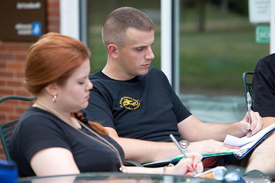 图为一名军校学生在咖啡厅外的桌子旁工作
