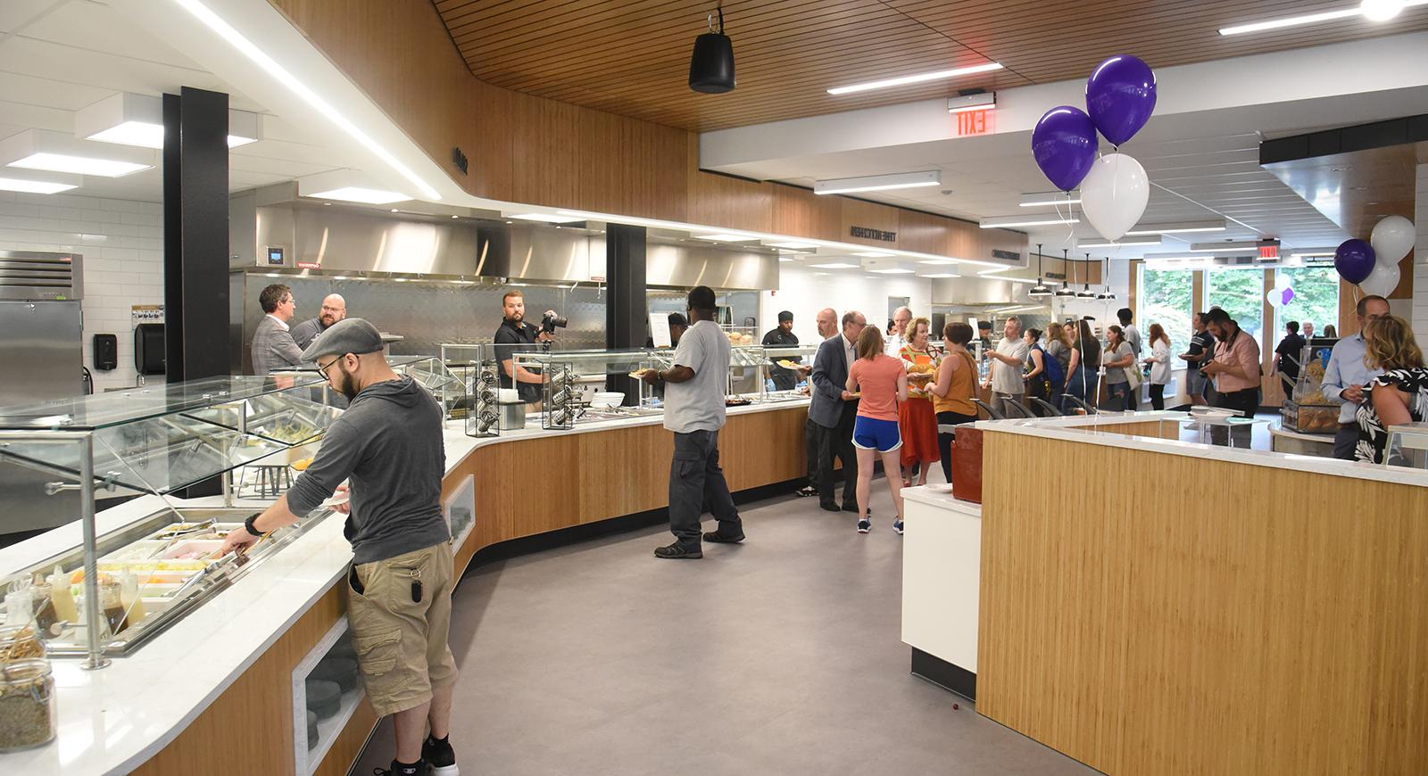 开放日，人们在安德森食堂里自己上菜的照片, 旁边有一些紫色的气球